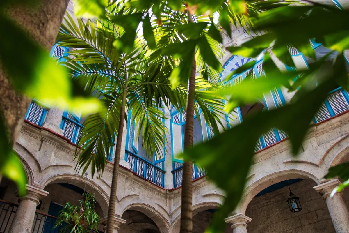BookNoFees-voorbeeldfoto: Tropische binnenplaats met palmbomen en historische balkons in Cuba