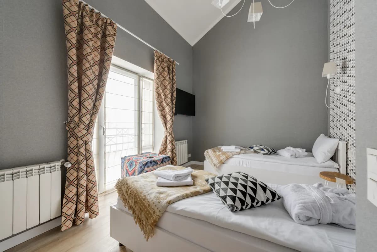 BookNoFees-voorbeeldfoto: Lichte slaapkamer met twee bedden en gordijnen met patronen