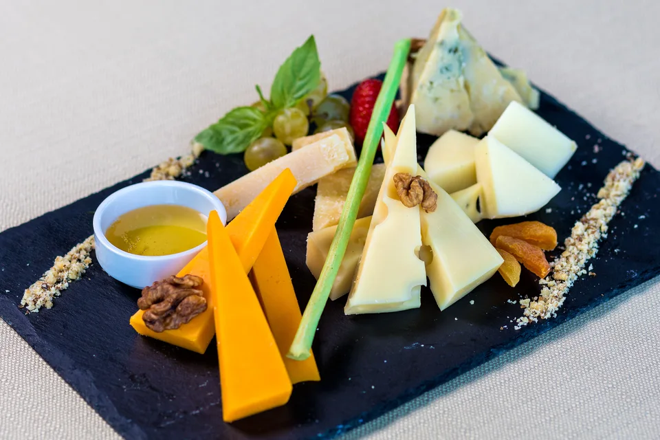 BookNoFees: Voorbeeldfoto: Assortiment kazen met fruit en noten op een serveerplank
