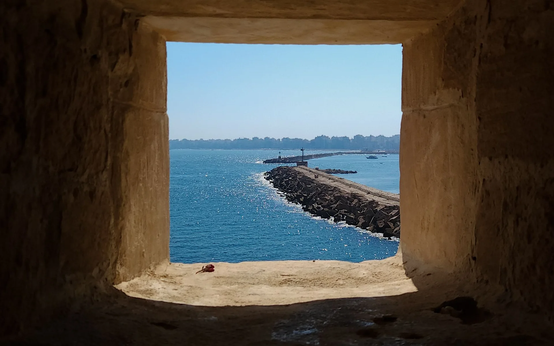 Uitzicht op de zee in Alexandrië door een historisch stenen raam
