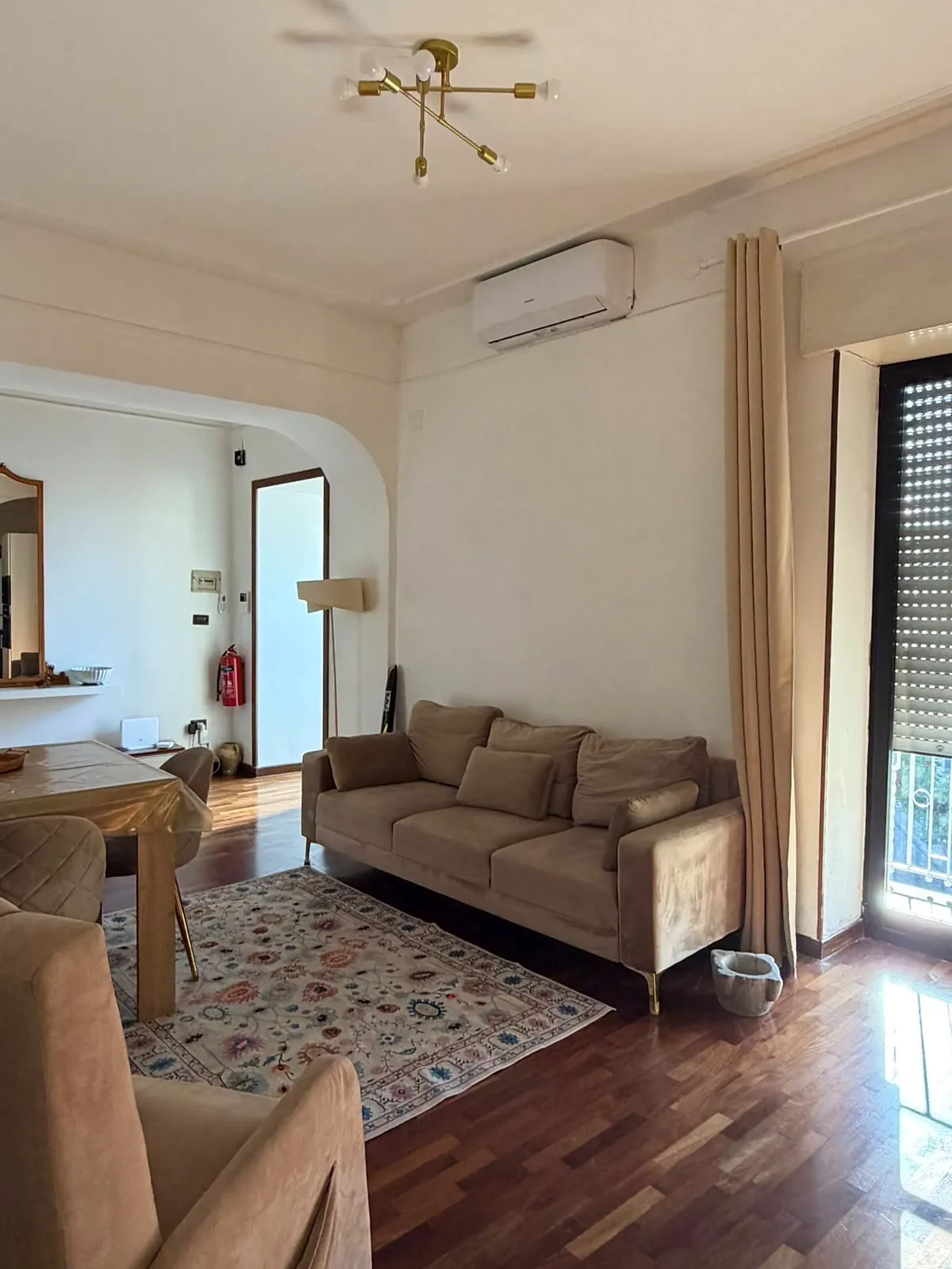 BookNoFees: vakantiehuis in Castellammare Di Stabia, De campagne, Italië – Woonkamer met een beige bank, een tapijt met patroon en een plafondventilator met een messing armatuur
