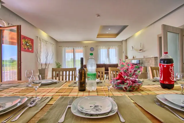 BookNoFees: vakantiehuis in Štokovci, Kroatië – een eettafel met borden en wijnflessen erop in Villa Stokovci in Štokovci