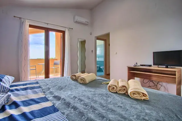 BookNoFees: vakantiehuis in Štokovci, Kroatië – een slaapkamer met een bed, handdoeken en een piano in Villa Stokovci in Štokovci