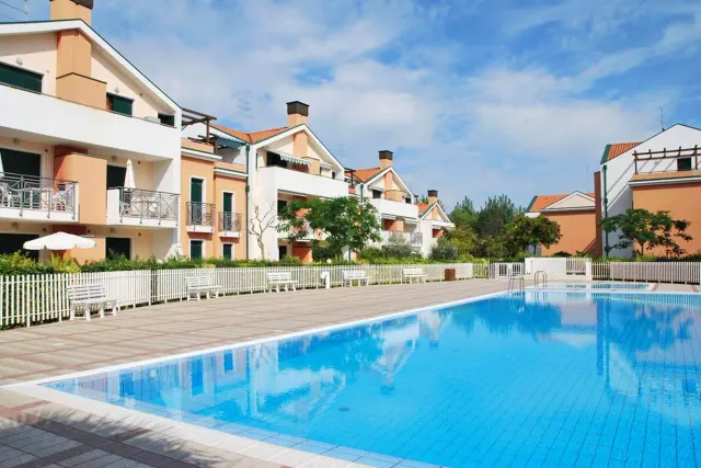 BookNoFees: vakantiehuis in Cavallino-Treporti, Italië – een groot zwembad tegenover een gebouw van Sunny Apartment On The Sea in Cavallino-Treporti