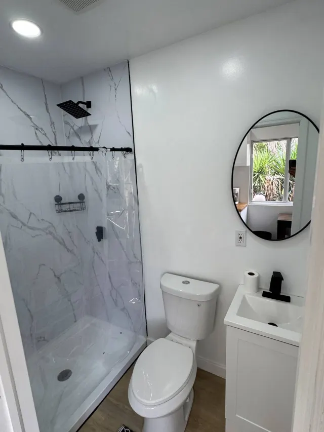 BookNoFees: vakantiehuis in Cutler Bay, Verenigde Staten – Badkamer met douche met marmerpatroon, toilet, wastafel en ronde spiegel