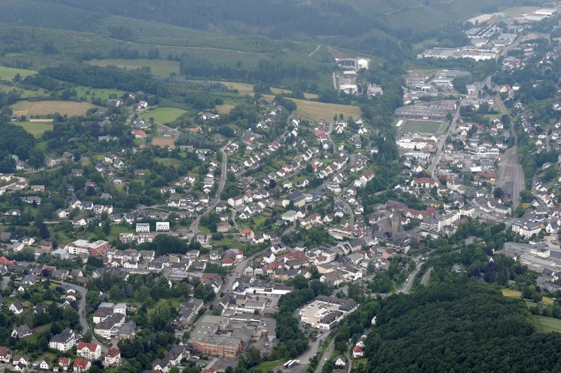 Het stadje Sundern vanuit de lucht, huizen langs het Röhr-dal tussen beboste heuvels