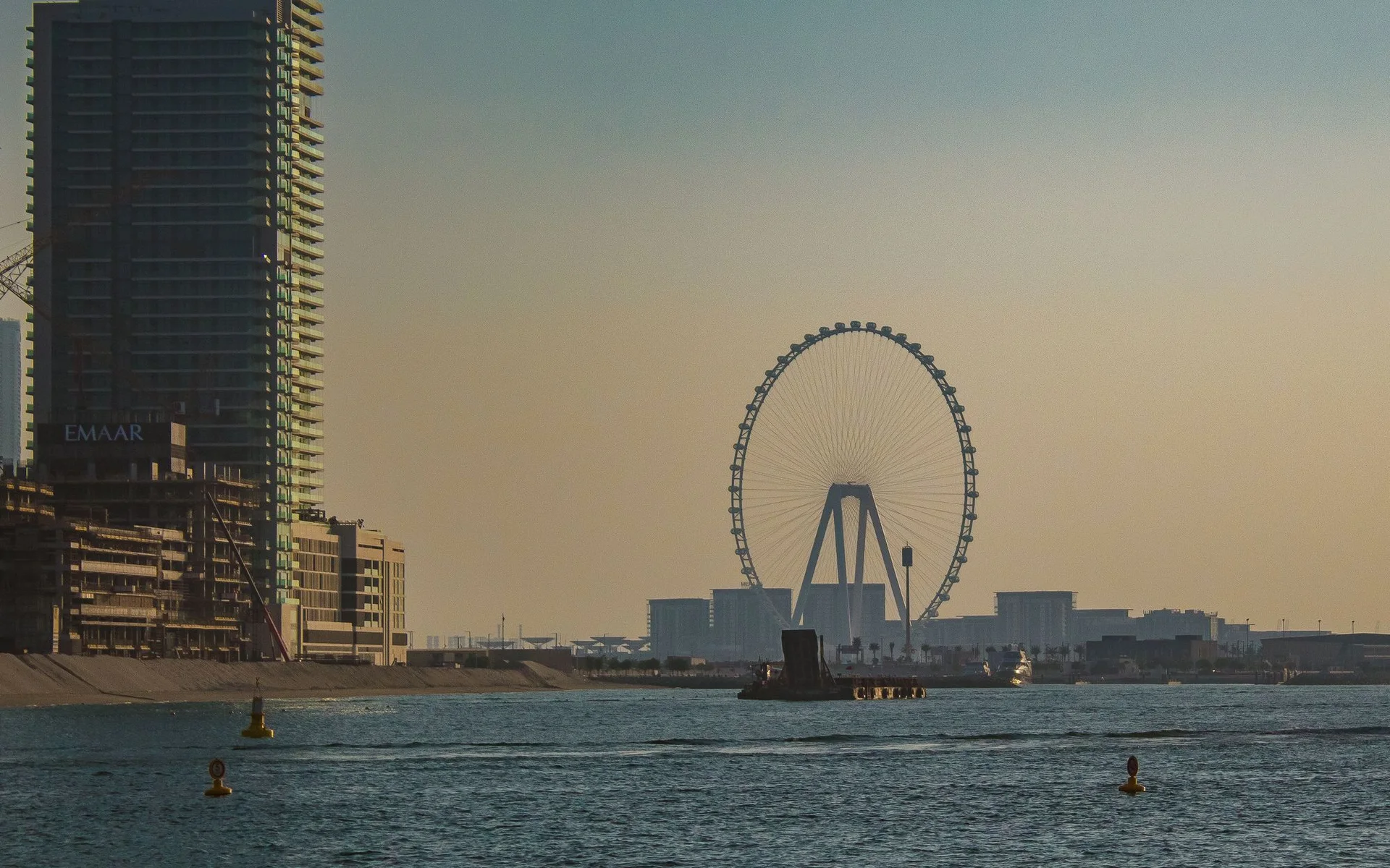 Skyline van Dubai met reuzenrad bij zonsondergang