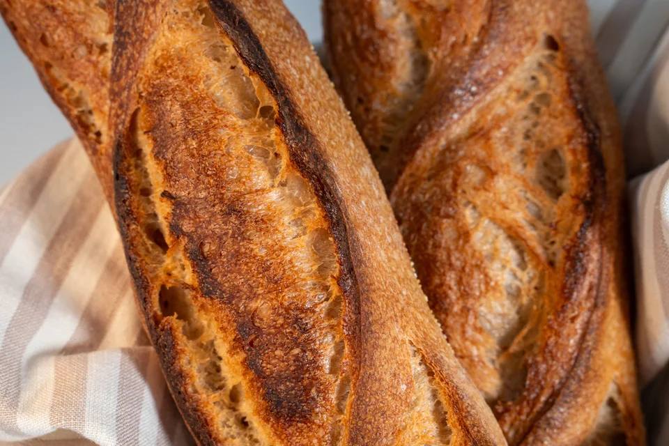 BookNoFees: Voorbeeldfoto: Goudbruine baguettes op een geruite tafelkleed