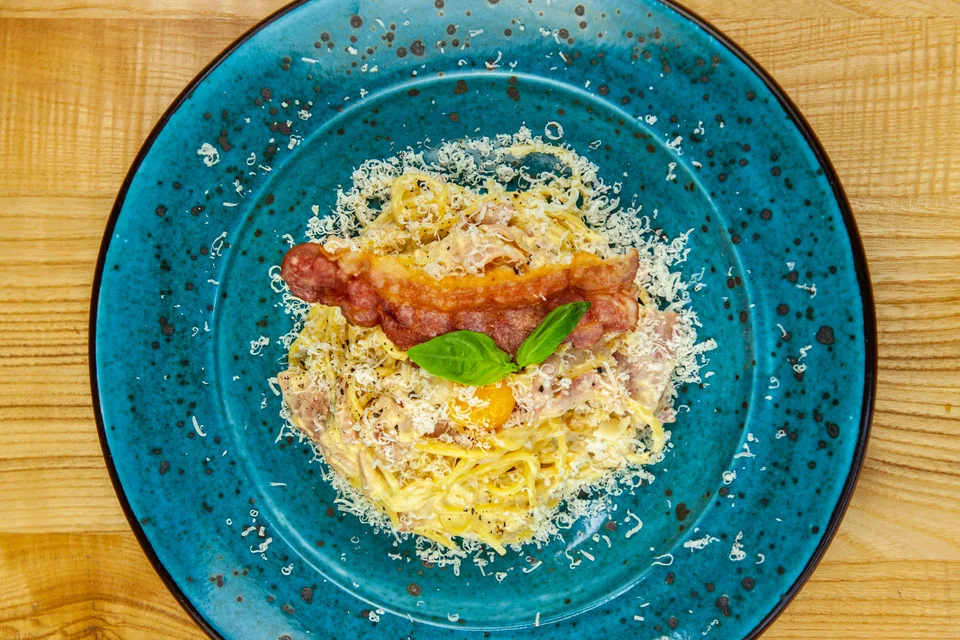 Voorbeeldfoto: Spaghetti carbonara op een blauw bord