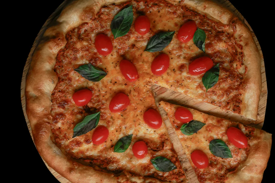 Voorbeeldfoto: Pizza belegd met tomaten en basilicum